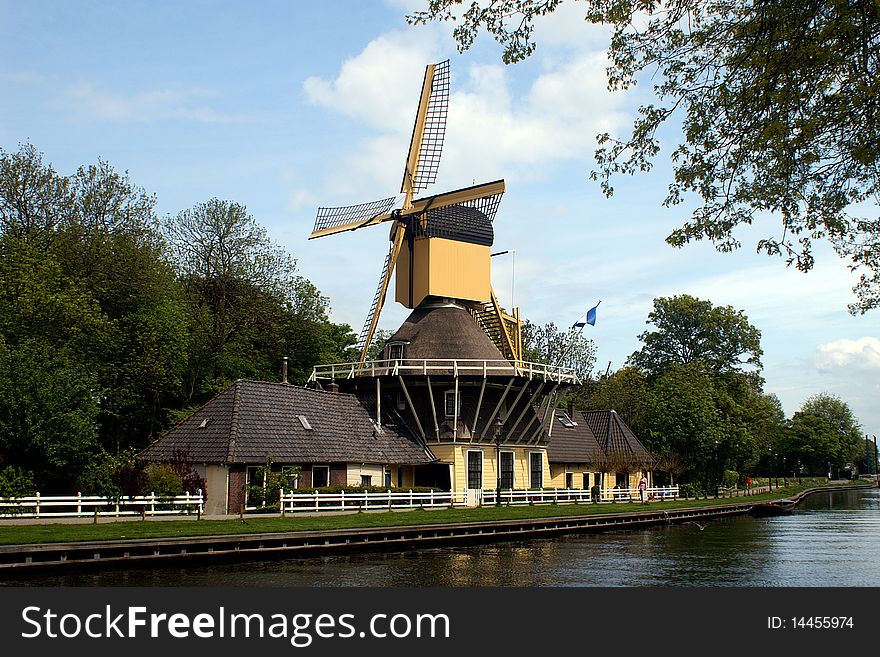 Dutch windmill and houses at the river shore