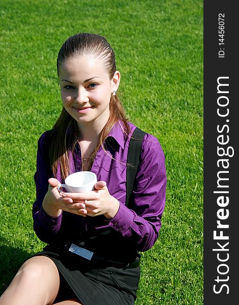 Student drinking tea at the park, green grass