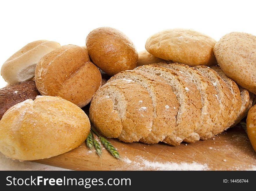 Different types of bread on a wooden board sprinkled with flour