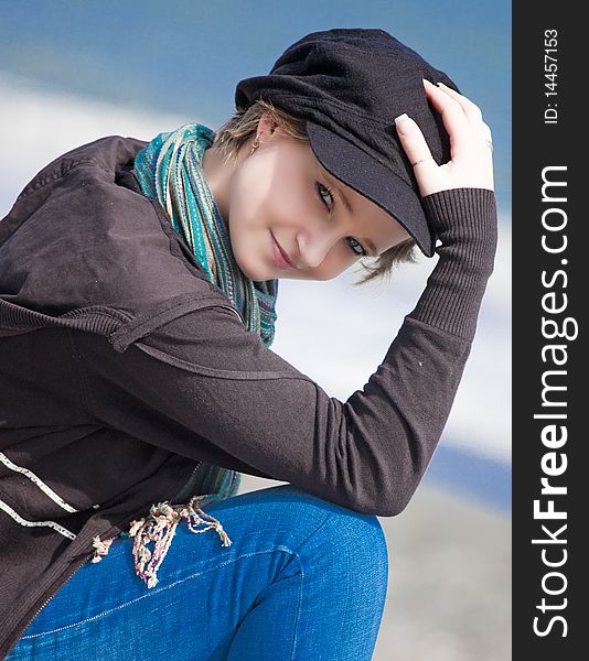 Blonde girl holding a black hat in the spring near the sea, her hand with long nails and treated. Blonde girl holding a black hat in the spring near the sea, her hand with long nails and treated