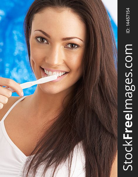 Young Woman Brushing Teeth In Studio At Camera