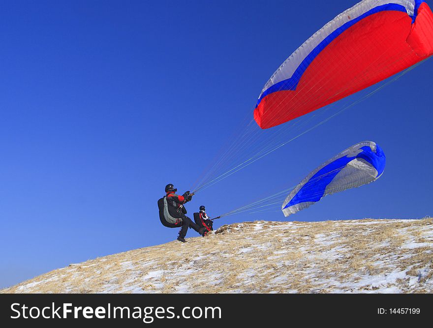 Two paragliders catching the wind for taking off