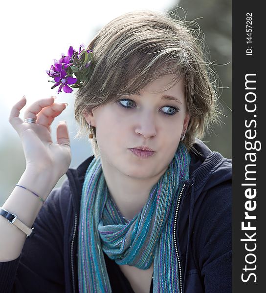 Blonde putting flowers in her hair, her hand with long nails and treated. Blonde putting flowers in her hair, her hand with long nails and treated