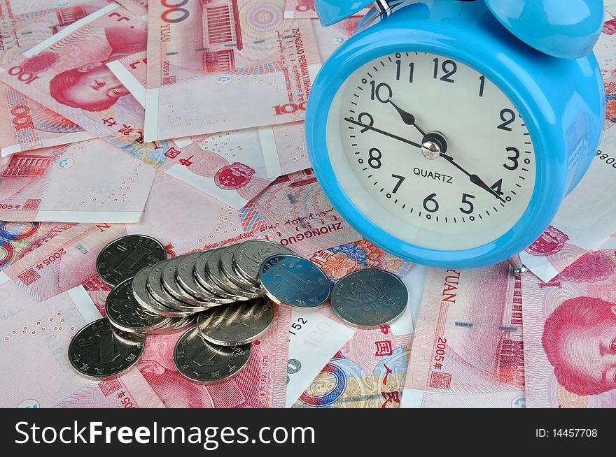 A blue clock with a lot of money note and coins, means time have relative with fortune and rich, or time is value and cost. A blue clock with a lot of money note and coins, means time have relative with fortune and rich, or time is value and cost.