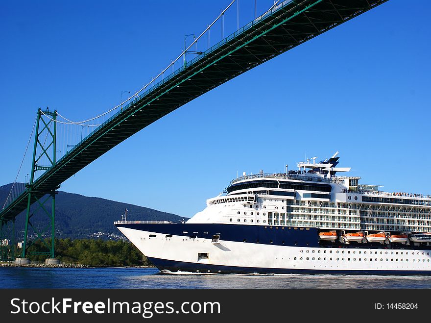 A cruise ship under a suspension bridge. A cruise ship under a suspension bridge