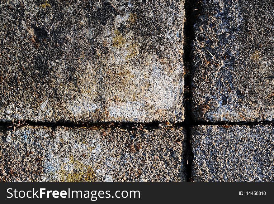 A Gray brick surface texture that is worn and old