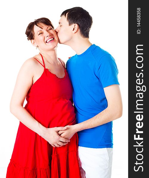 Young happy pregnant woman and her husband embracing and kissing