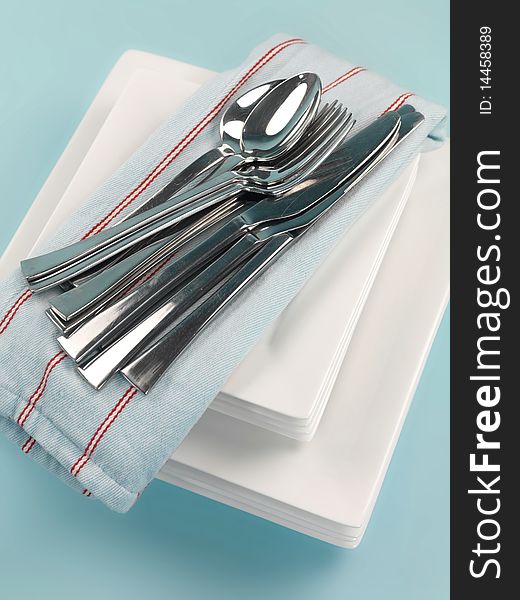 Plates and cutlery isolated against a blue background