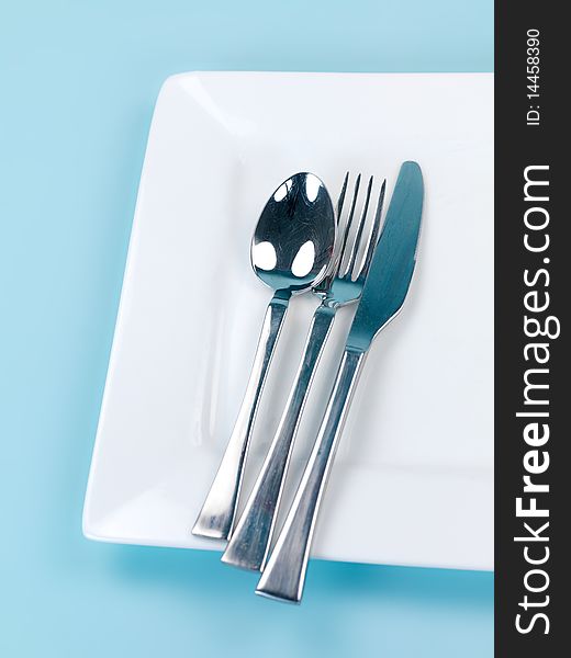 Plates and cutlery isolated against a blue background