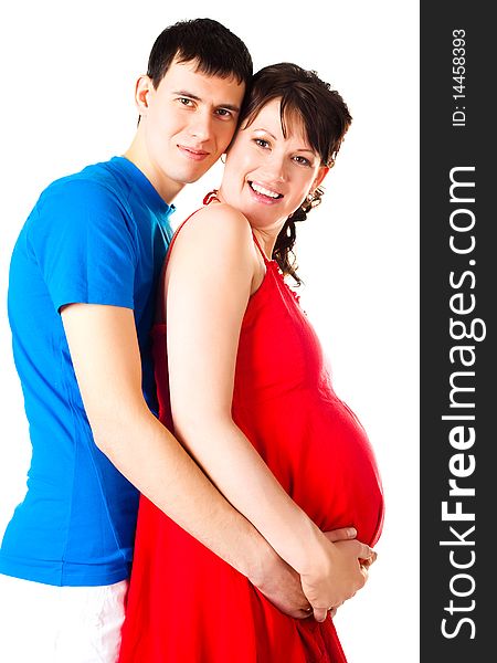 Young happy pregnant woman and her husband embracing and laughing