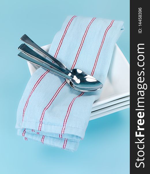 Plates and cutlery isolated against a blue background