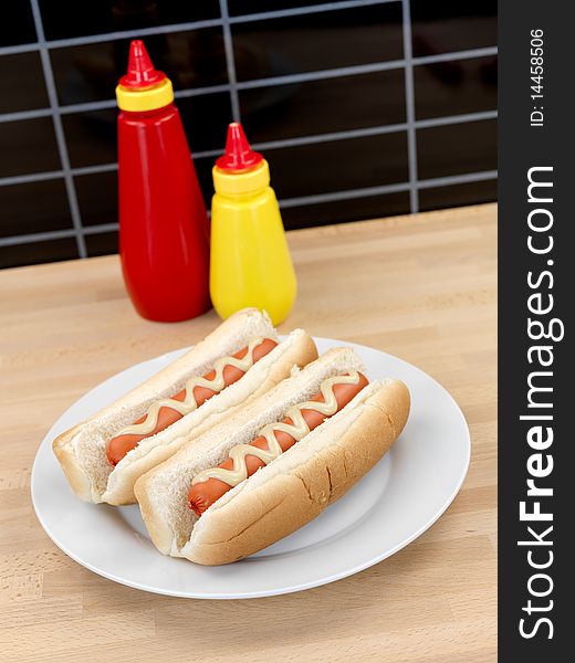 A hotdog with mustard sauce on a kitchen bench. A hotdog with mustard sauce on a kitchen bench