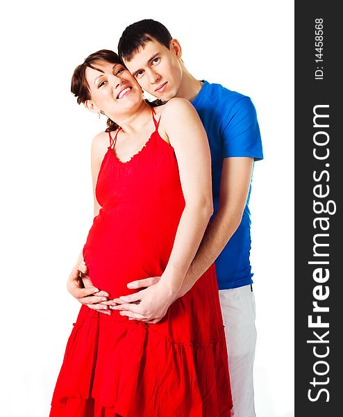 Young happy pregnant woman and her husband embracing and laughing