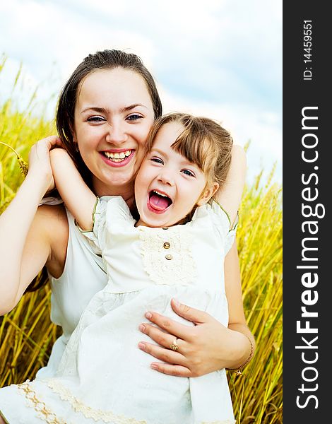 Beautiful young mother and her daughter having fun at the wheat field. Beautiful young mother and her daughter having fun at the wheat field