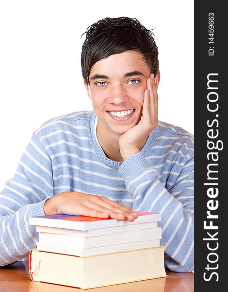 Young student is sitting on desk with his books and smiles happy into camera. Isolated on white. Young student is sitting on desk with his books and smiles happy into camera. Isolated on white.