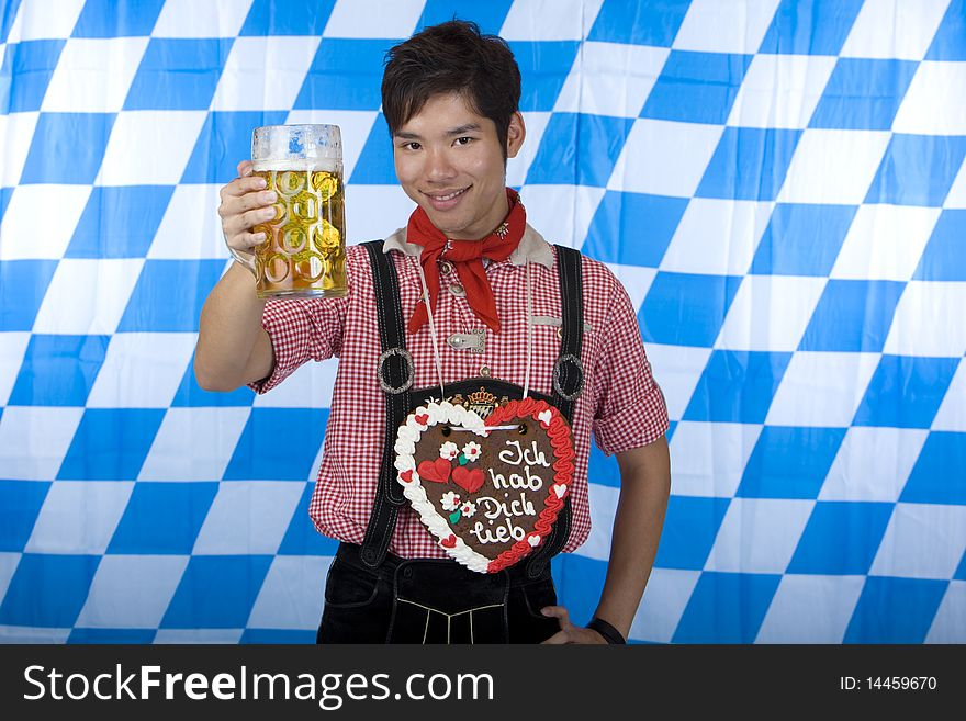 Young happy Asian man holds Oktoberfest beer stein