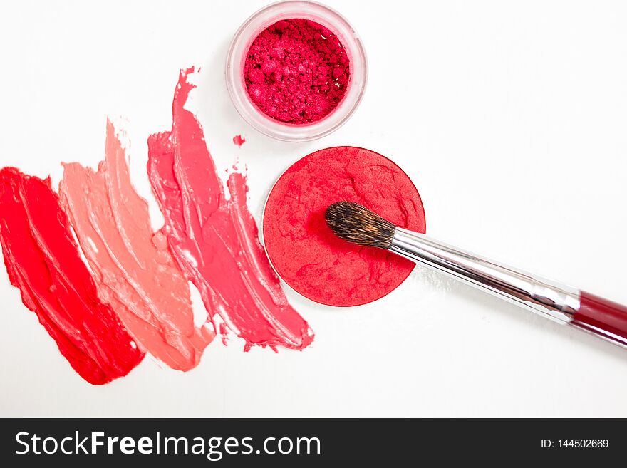 Lipstick and lip gloss, drops and strokes of different shades With brushes for application and shading, white background