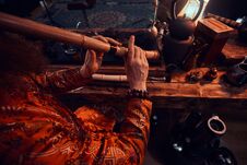 Tradition, Health, Harmony. Chinese Tea Ceremony. Tea Master In Kimono Performs In The Dark Room With A Wooden Interior Stock Images Tradition, Health, Harmony. Chinese Tea Ceremony. Tea Master In Kimono Performs In The Dark Room With A Wooden Interior Stock Images