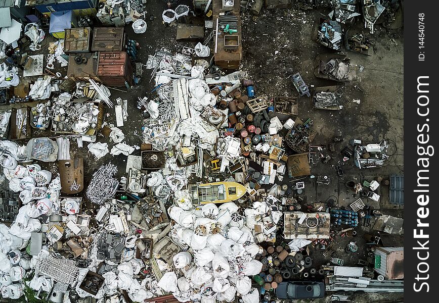 Scrap metal junkyard area aerial view. Reception and storage metal waste before recyclyng.Dark toned