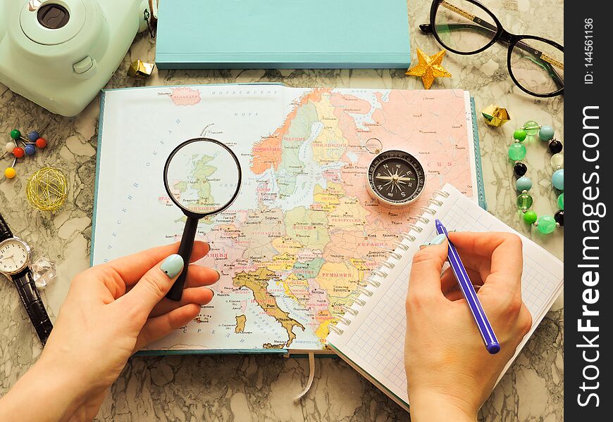 Top View of a map and items. Planning a trip or adventure. Travel planning dreams. Map of the world. Travel, tourism and vacation concept background. Stylish notebook, map and magnifier. Flat lay.