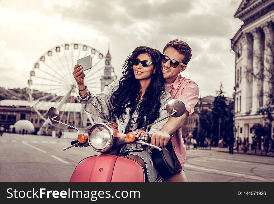 Beautiful memories. Positive nice couple standing together while taking a photo of themselves. Beautiful memories. Positive nice couple standing together while taking a photo of themselves