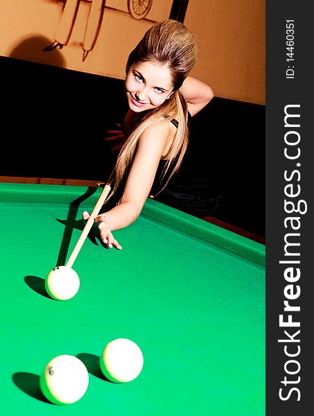 Beautiful young blond woman playing billiard in the bar. Beautiful young blond woman playing billiard in the bar