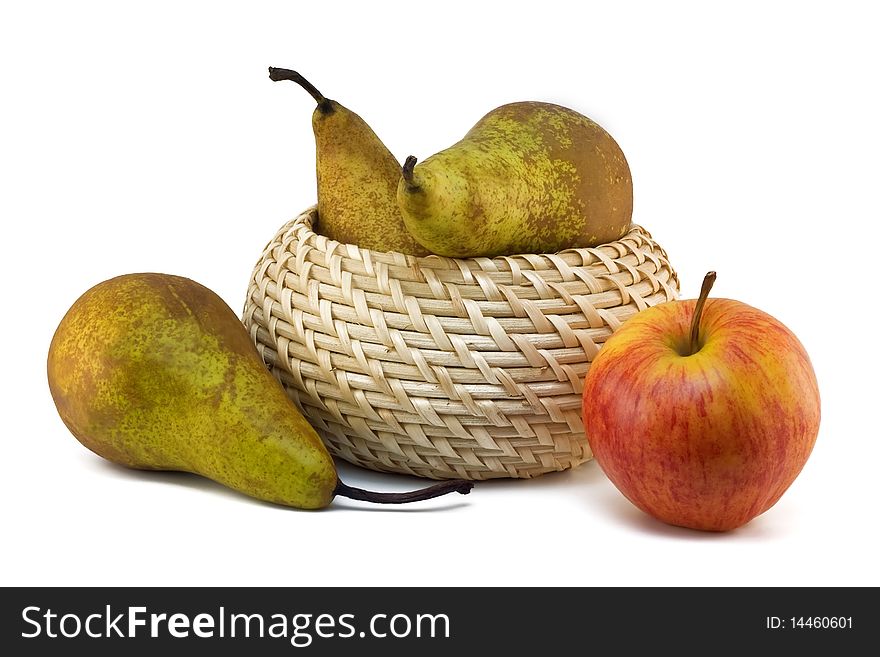 Green pears, red apple and a wattled straw basket on a white background. Green pears, red apple and a wattled straw basket on a white background