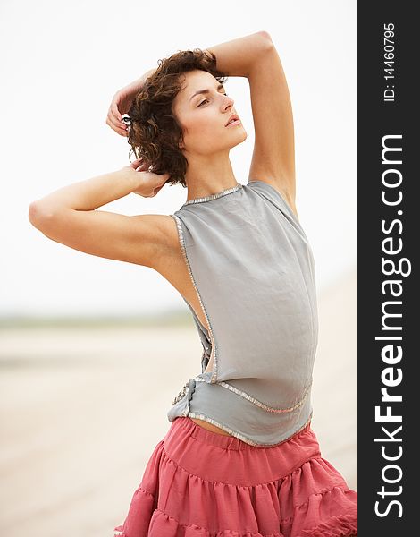 Attractive Young Woman Standing Amongst Sandunes