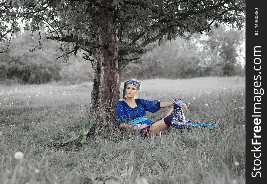 Woman sitting on the grass near the tree. Woman sitting on the grass near the tree