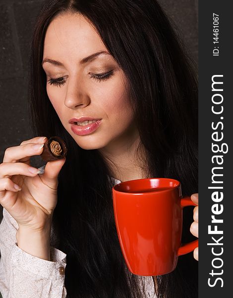 Beautiful lady drinking tea with chocolate candies