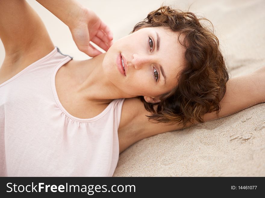 Young Woman Laying Amongst Sand Dunes