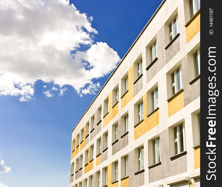 Yellow building with windows over blue sky