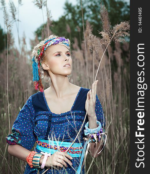 Beautiful young woman standing on yellow grass