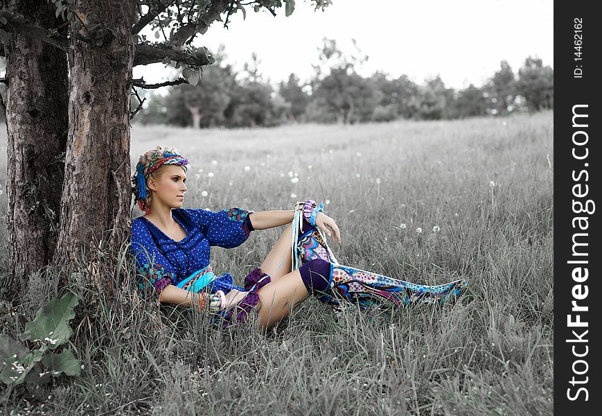 Beautiful young woman sitting on the grass