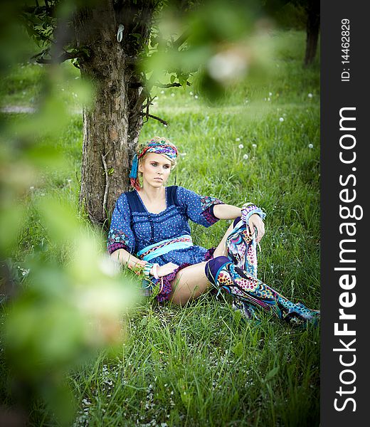 Beautiful young woman sitting on the grass