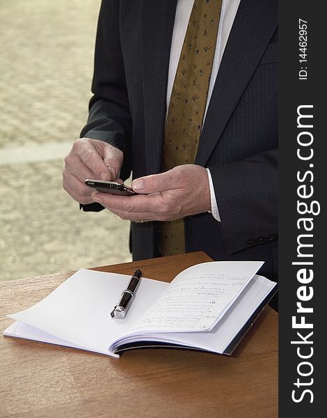 Well dressed business man with cell phone and calendar.