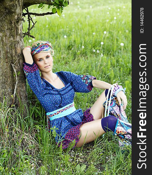 Beautiful young woman sitting on the grass