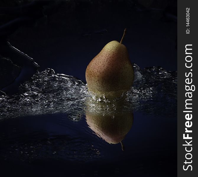 Pear with teflection in water splash studio shot. Pear with teflection in water splash studio shot