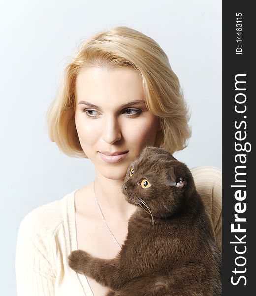 Beautiful young woman keeping a cat in the hands