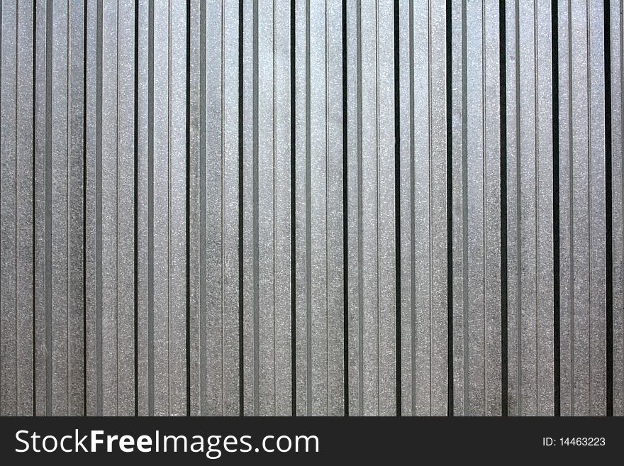 Corrugated, silvery iron, grey colour. Corrugated, silvery iron, grey colour