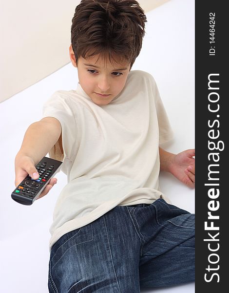 A boy holding a remote control reclining isolated. A boy holding a remote control reclining isolated