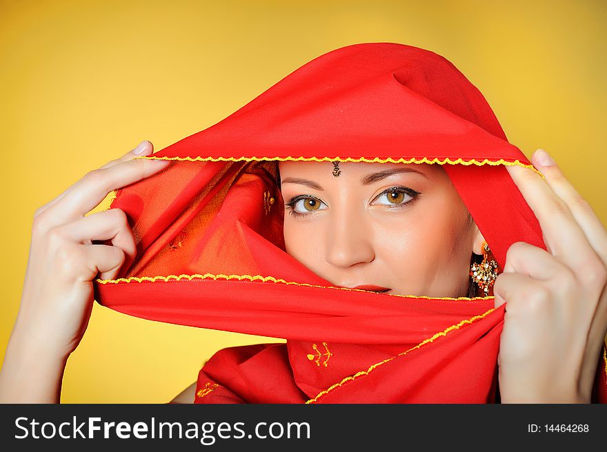 Young beautiful woman eyes in indian traditional jewellary, bindi , sari dress and makeup. yellow background. Young beautiful woman eyes in indian traditional jewellary, bindi , sari dress and makeup. yellow background