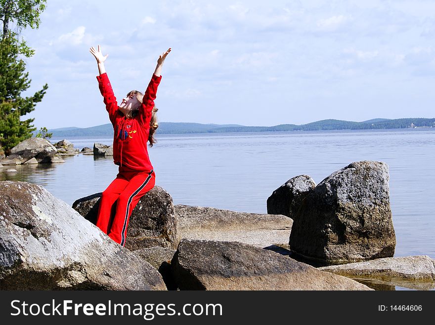 In the summer on the nature the joyful child looks upwards having lifted hands to the sky. In the summer on the nature the joyful child looks upwards having lifted hands to the sky