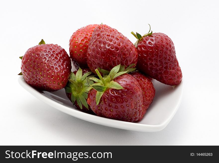 Strawberries on plate on white background