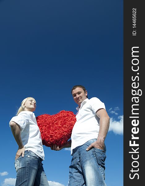 Couple of young people, loving boy and girl holding hands in the heart of roses. Couple of young people, loving boy and girl holding hands in the heart of roses