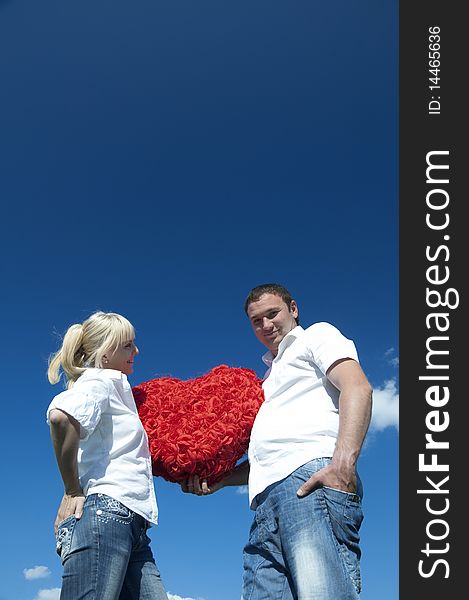 Couple of young people, loving boy and girl holding hands in the heart of roses. Couple of young people, loving boy and girl holding hands in the heart of roses