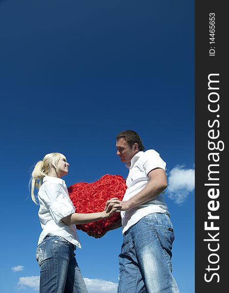 Couple of young people, loving boy and girl holding hands in the heart of roses. Couple of young people, loving boy and girl holding hands in the heart of roses