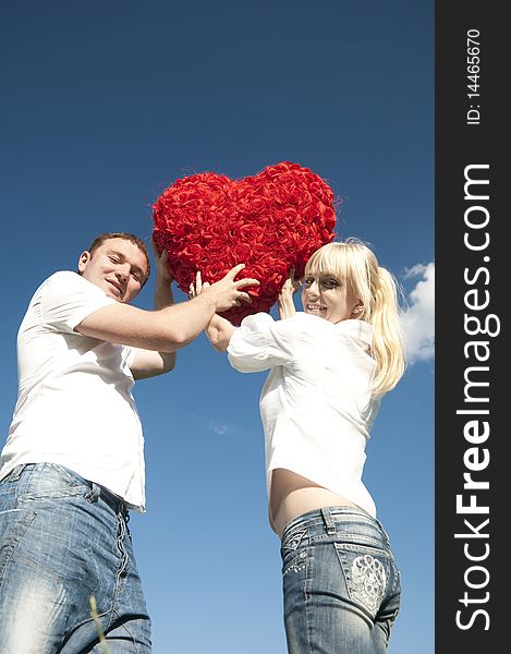 Couple of young people, loving boy and girl holding hands in the heart of roses. Couple of young people, loving boy and girl holding hands in the heart of roses