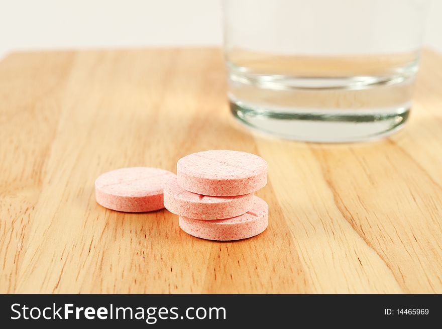 Pink tablets and glass on the table