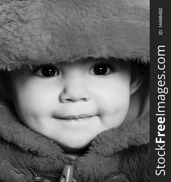 Girl looking at the camera and smiling with hood. Black and white image. Girl looking at the camera and smiling with hood. Black and white image